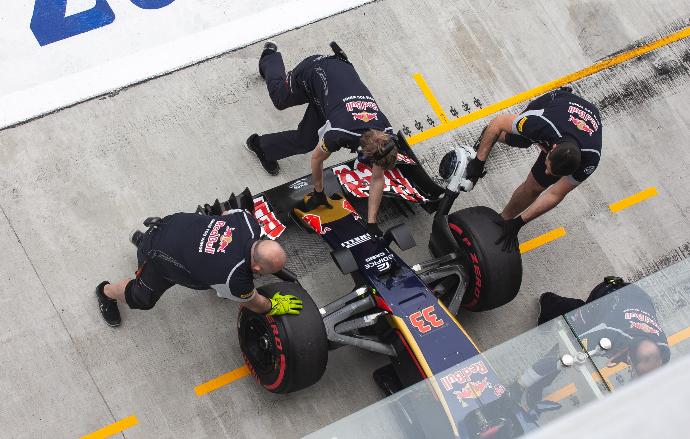 three men at pit stop fixing formula one vehicle